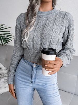 Dark gray acrylic cable knit cropped mock neck sweater with cuffed sleeves and hem.