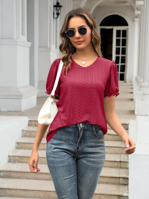 Burgundy eyelet puff sleeve v-neck blouse with textured pattern and ruffled cuffs.