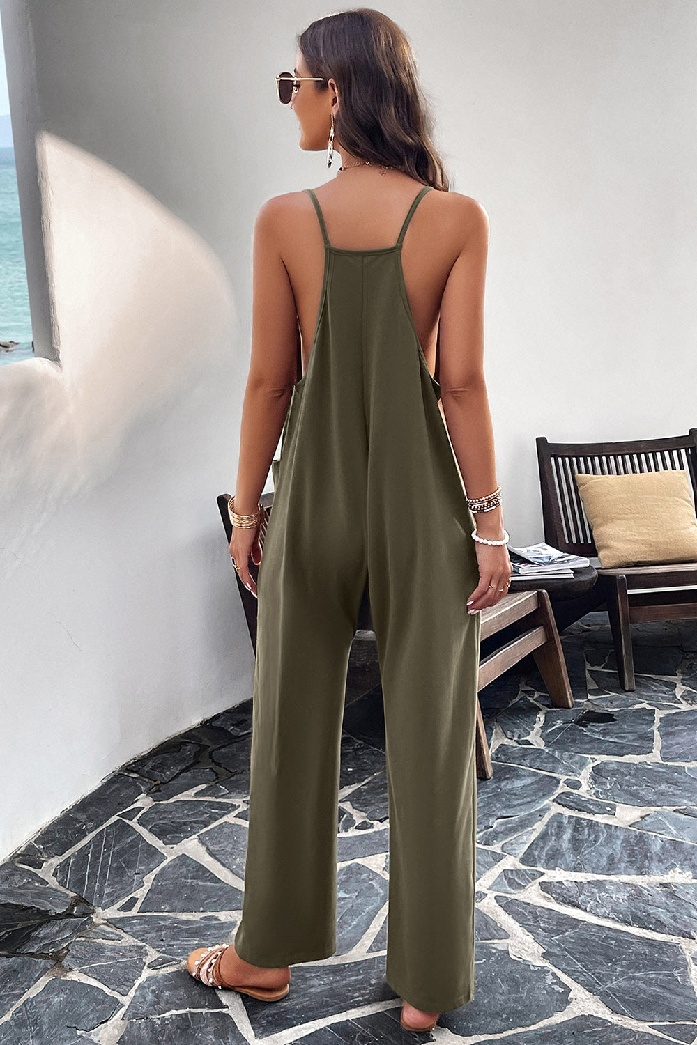Army green relaxed drape pocket jumpsuit with spaghetti straps and wide legs.