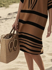 Striped half sleeve midi dress in Tan with black stripes, worn with a straw bag.