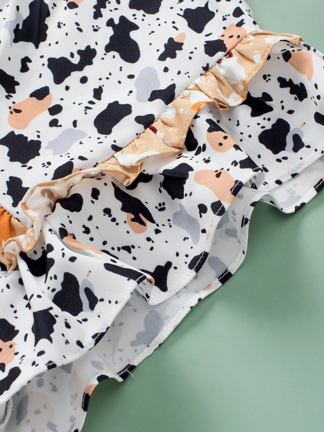 White blouse with terrazzo print and ruffled yoke detail.