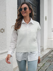 White cable knit V-neck sleeveless sweater vest over a white button-up shirt.
