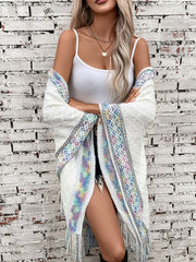 White knit hooded wrap with colorful embroidered trim and fringe.