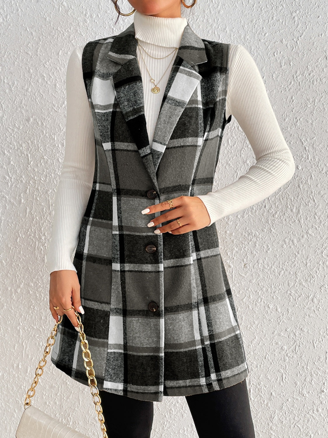 Black plaid sleeveless blazer dress with button front and notched lapels.