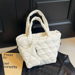 Ivory quilted shopper bag with diamond pattern and zippered pocket.