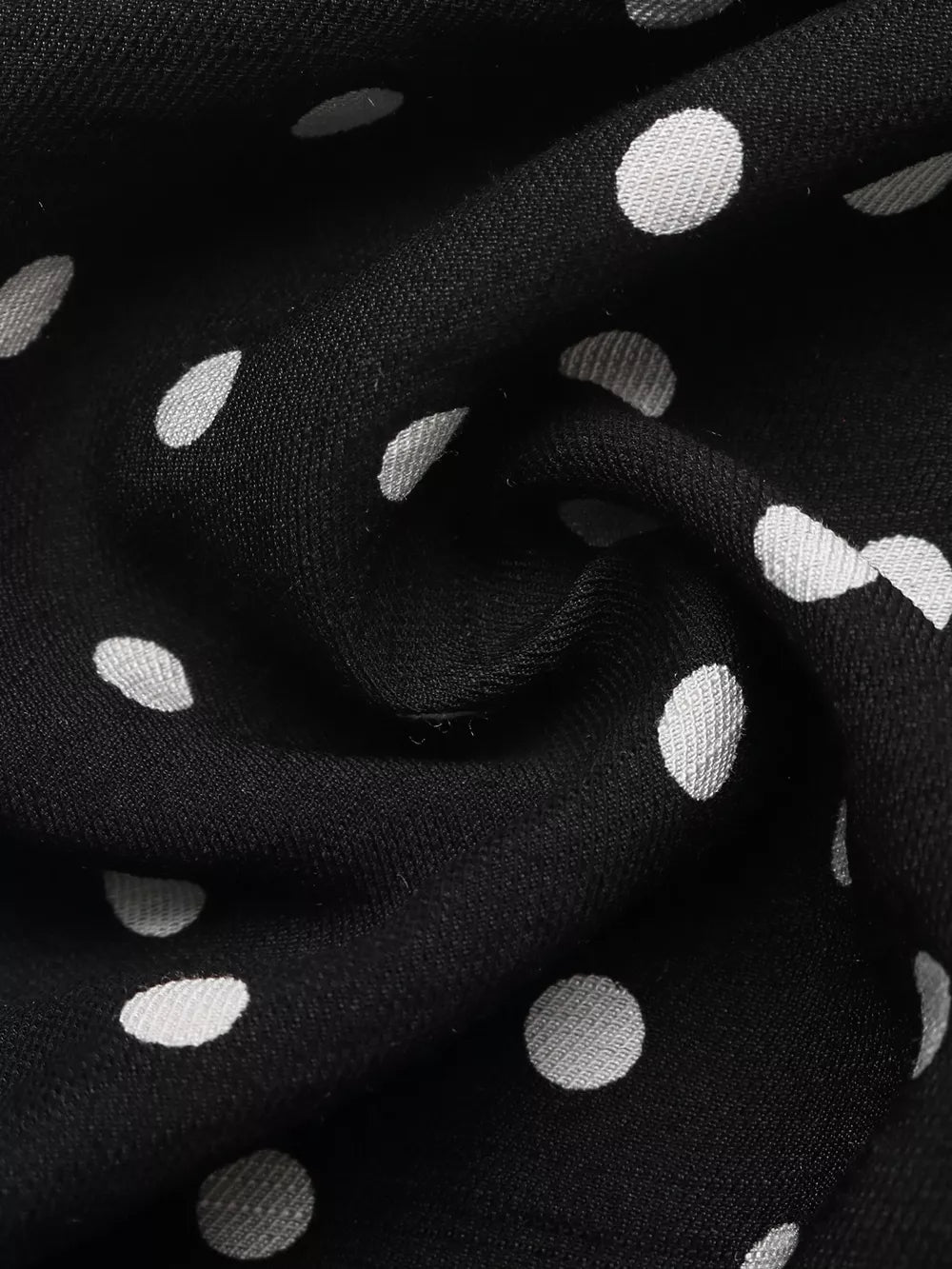 Black polka dot dress fabric with a ruffled hem detail
