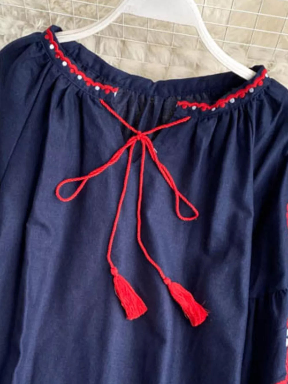 Navy blue peasant blouse with red embroidered neckline and tie tassels