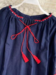 Navy blue peasant blouse with red embroidered neckline and tie tassels