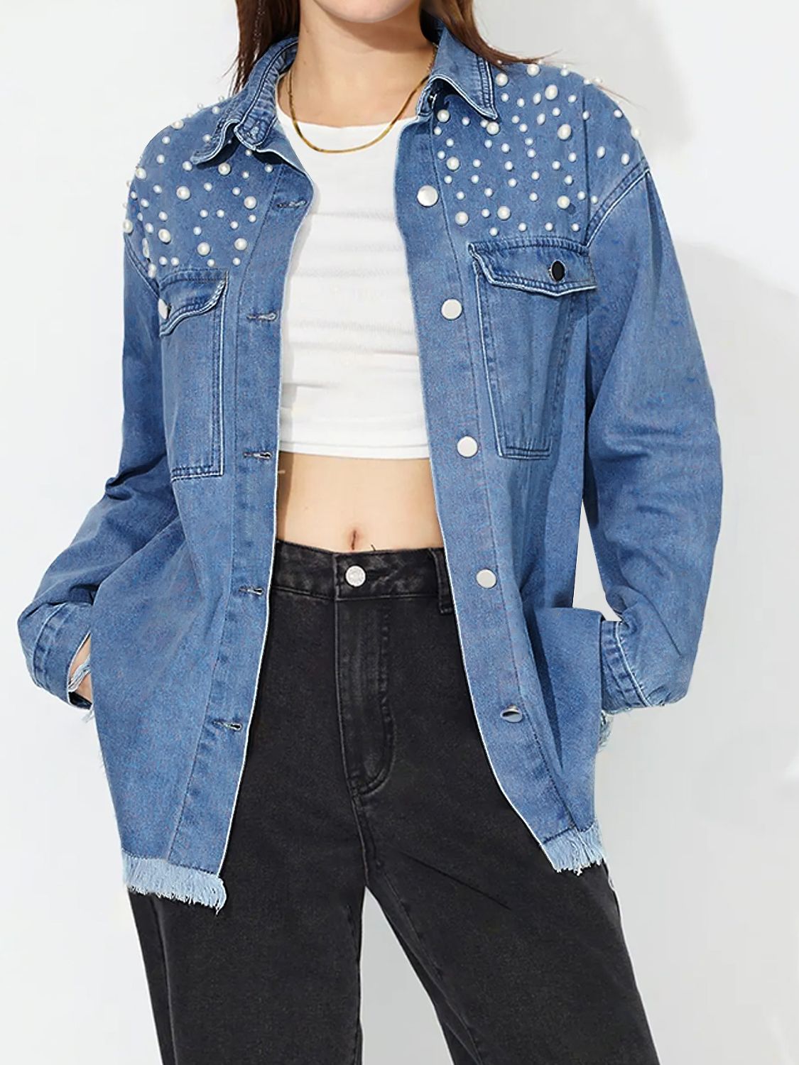 Medium wash denim shirt with pearl embellishments and frayed hem.