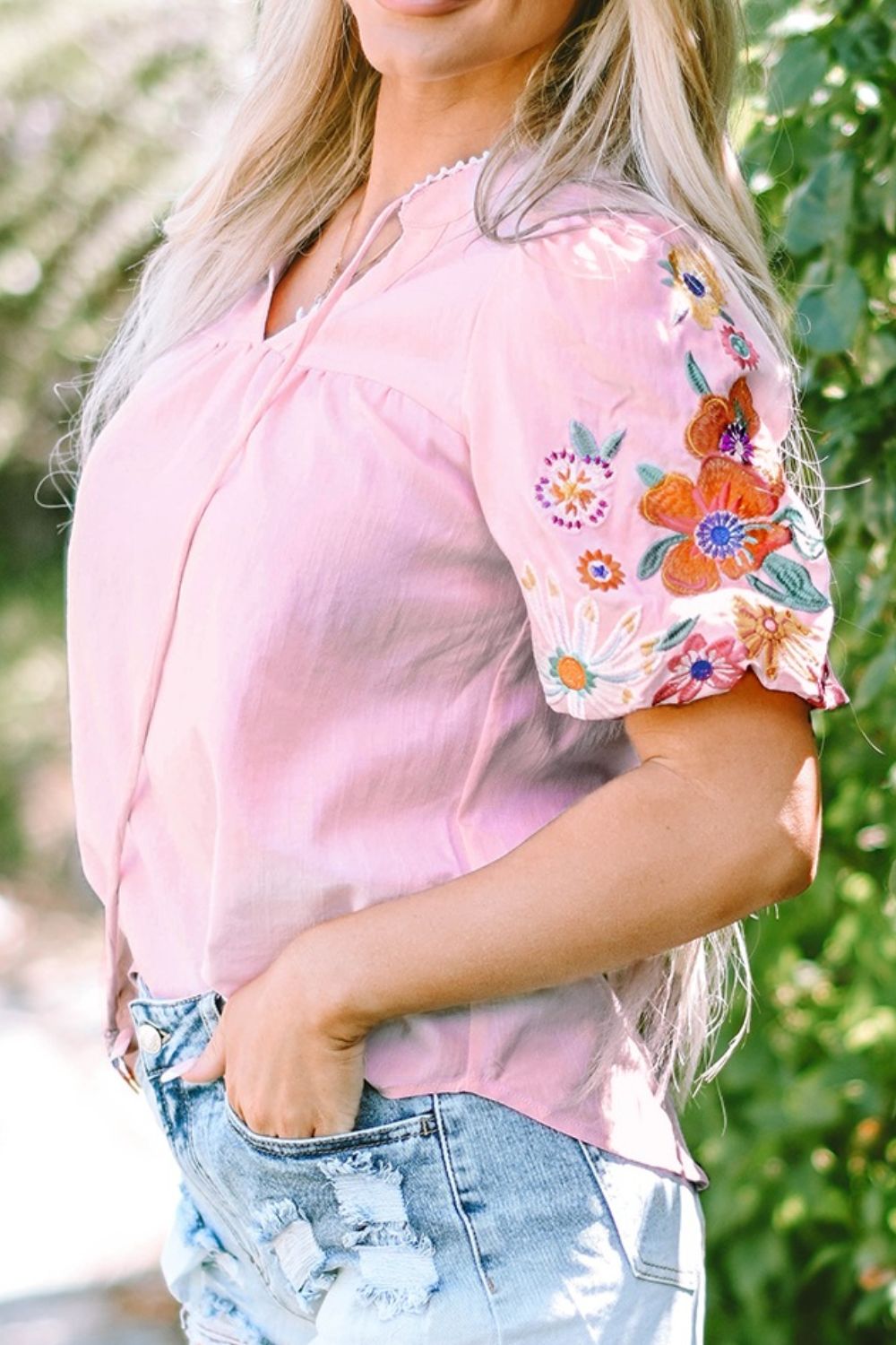 Dusty pink peasant blouse with embroidered floral puff sleeves and tie neck.
