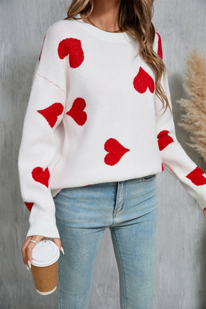 White acrylic knit jumper with red heart intarsia pattern, crew neck, long sleeves.