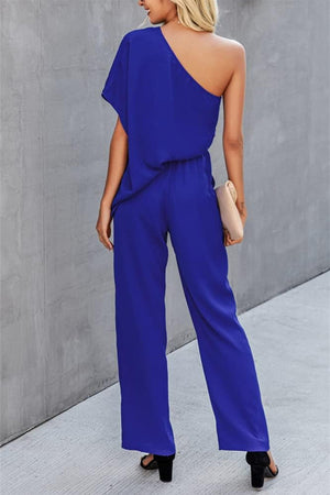 Royal blue asymmetric drape-sleeve wide-leg jumpsuit with a cinched waist.