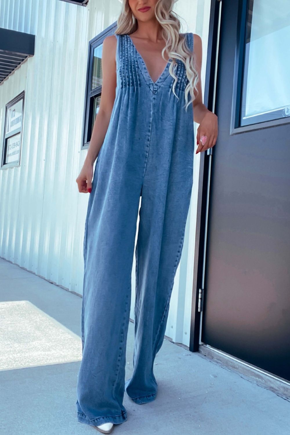 Medium denim jumpsuit with pleated bodice and wide legs.