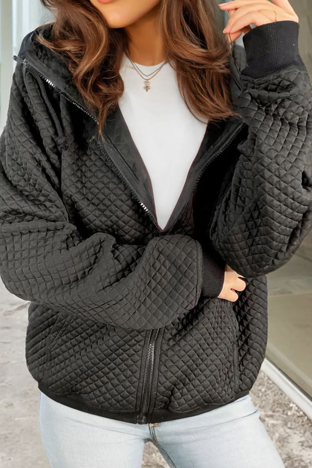 Black quilted zip-through hoodie with drawstring and ribbed cuffs.
