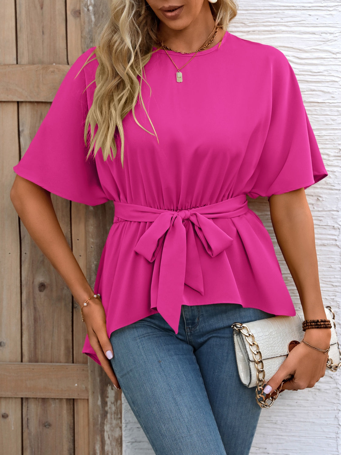 Hot pink blouse with short dolman sleeves and a self-tie belt at the waist.