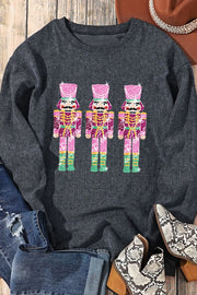Black ribbed sweatshirt with three pink nutcracker embellishments.
