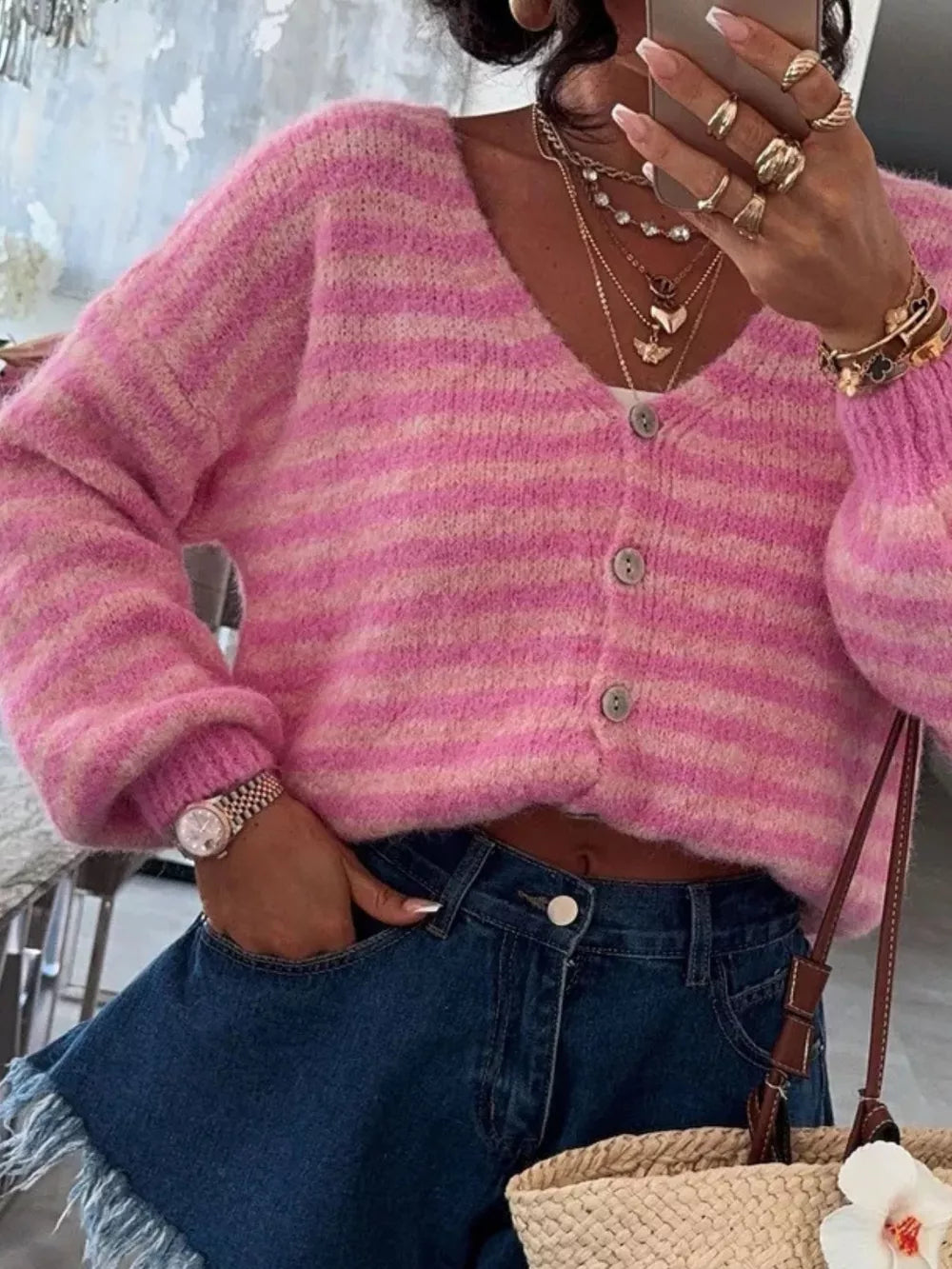 Pink striped cropped knit cardigan with V-neck and button closure.