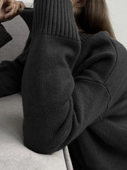 Black ribbed turtleneck sweater with flared sleeves and textured knit detail