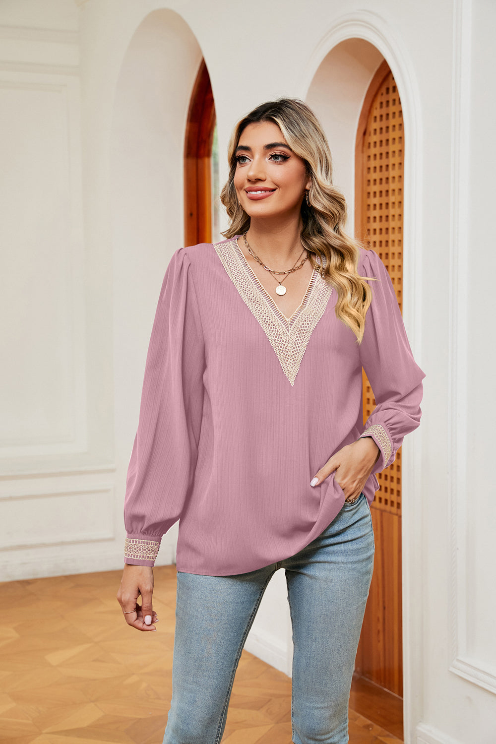 Blush pink blouson top with V-neck, embroidered trim, and long sleeves.