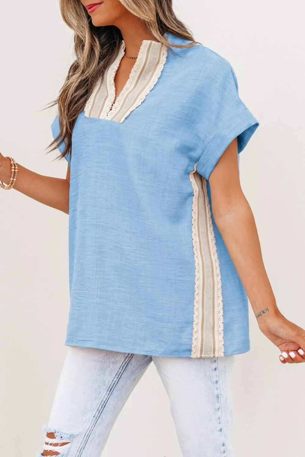 Blue polyester pullover shirt with V-neck, lace trim, and short sleeves.