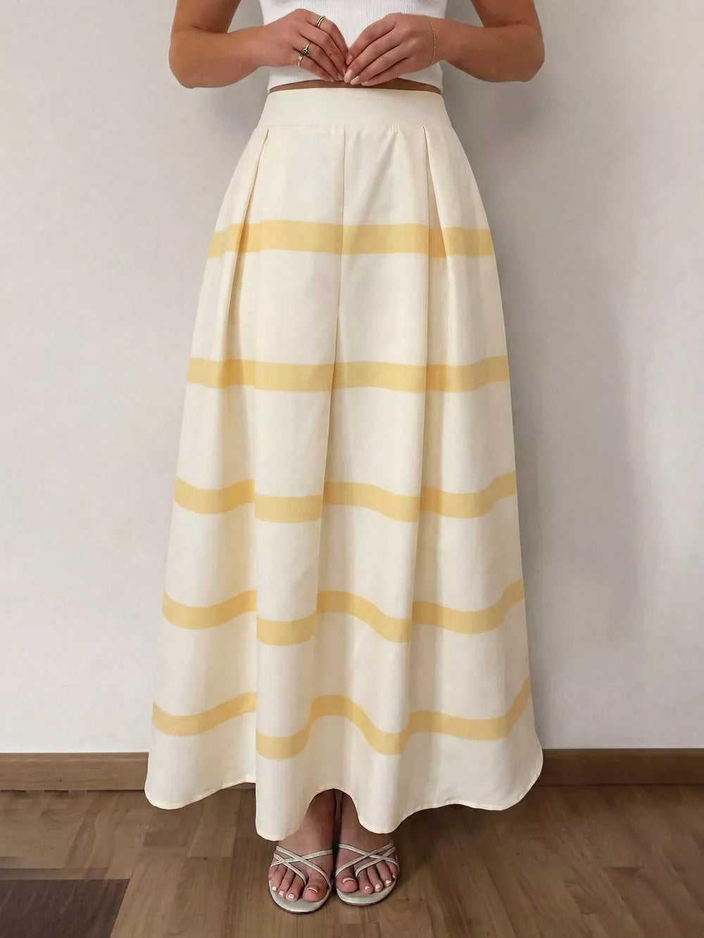 Flowy maxi skirt with yellow stripes, pleats, and pockets.