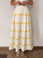 Flowy maxi skirt with yellow stripes, pleats, and pockets.