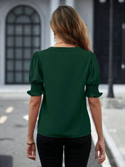 Dark green blouse with shirred sleeve cuffs and a V-neckline.