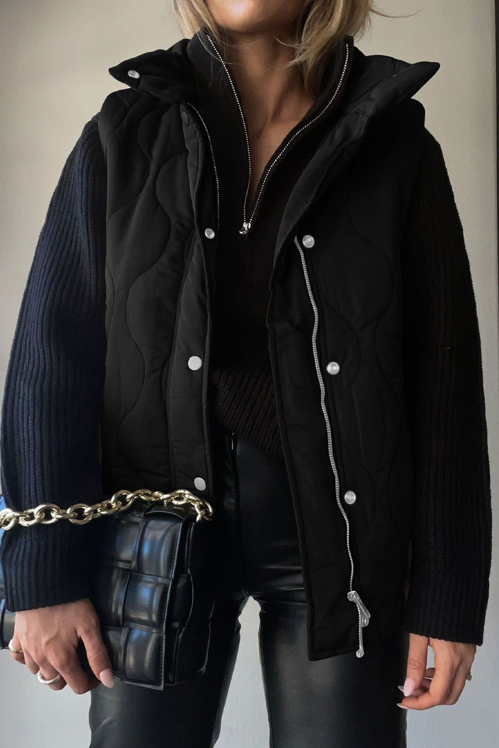 Black quilted stand-collar utility gilet with silver hardware and snap closures.