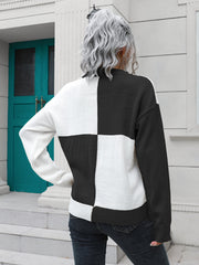 Colorblock knit sweater with black and white checkerboard pattern, crew neck, long sleeves.