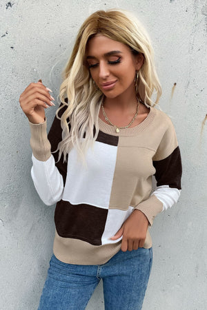 Geometric panel knit sweater in black, tan, white, and brown with crew neck and long sleeves.