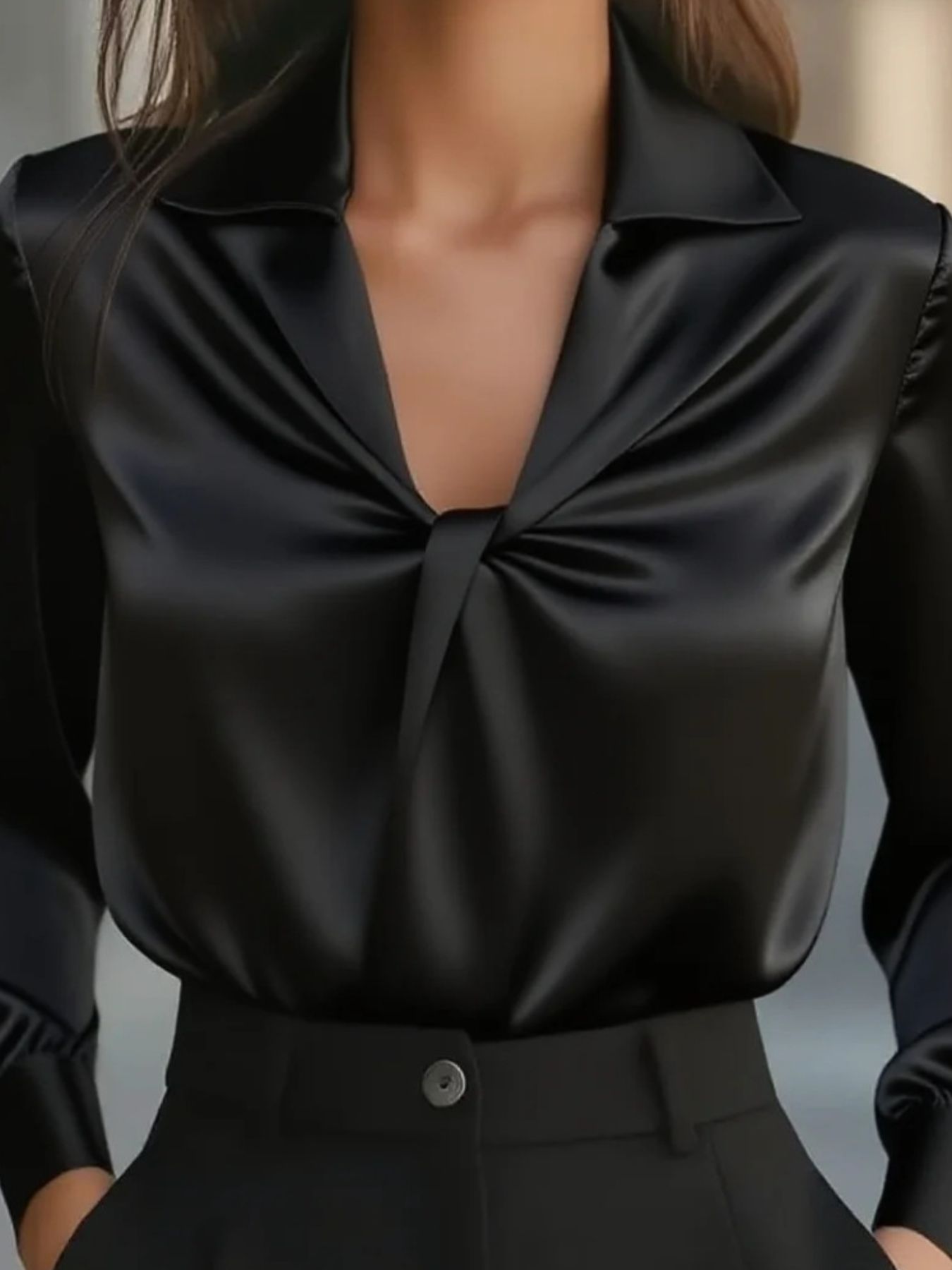 Black satin blouse with ruched front and long sleeves.