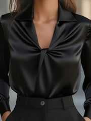 Black satin blouse with ruched front and long sleeves.