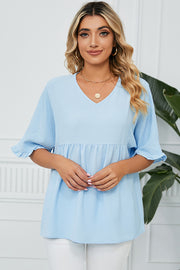 Light blue gathered yoke blouse with flutter sleeves and v-neckline.
