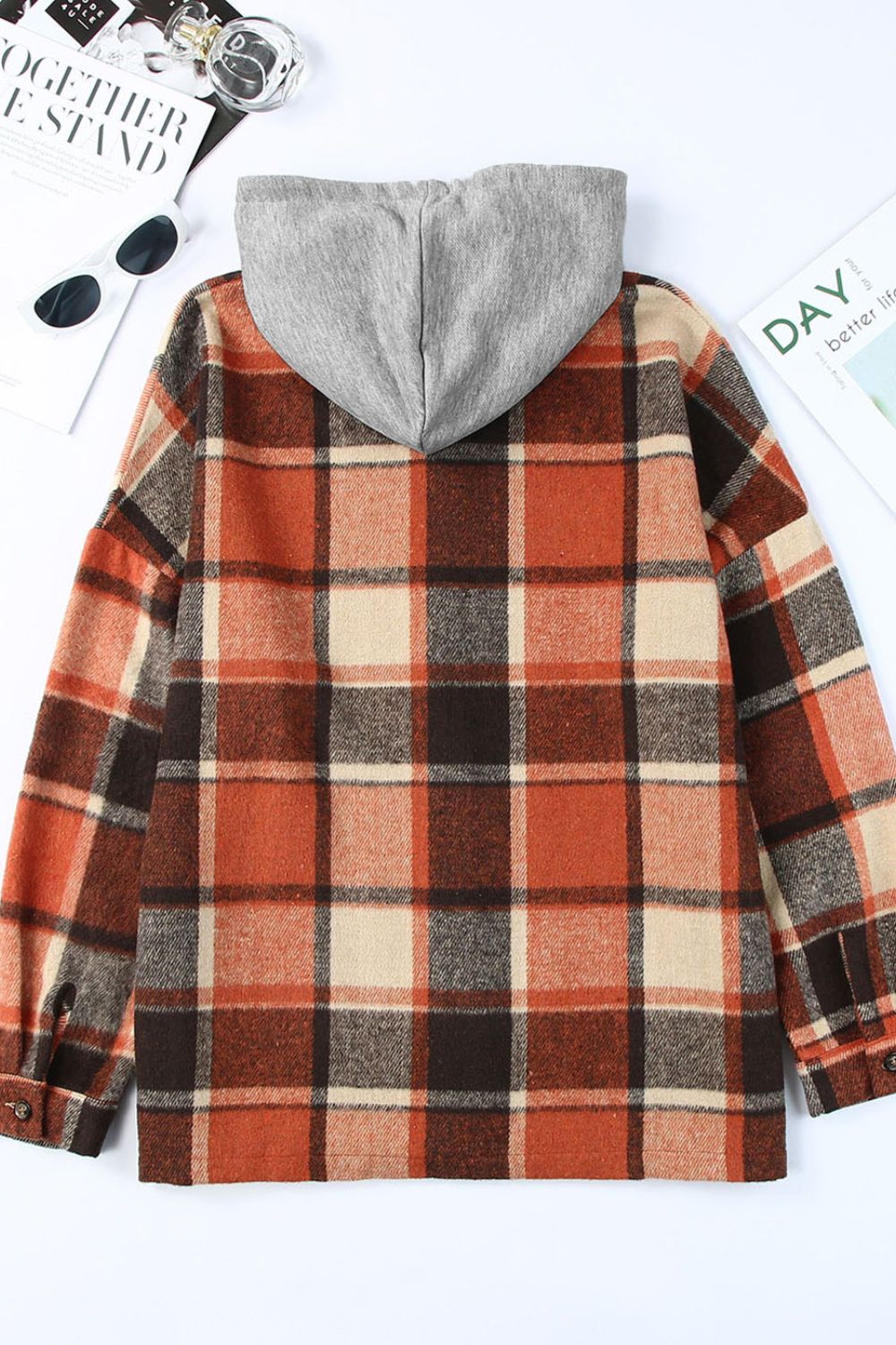 Plaid hooded shacket in orange, tan, and brown checkered pattern with a relaxed fit.