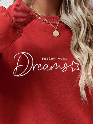 Deep Red oversized sweatshirt with white "follow your Dreams" script graphic and star detail.