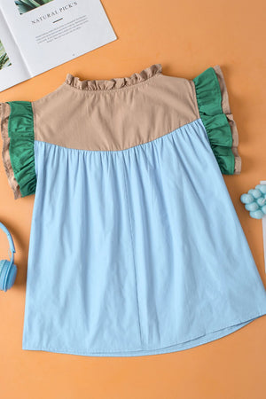 Colorblock ruffle yoke blouse in light blue with tan and green accents.