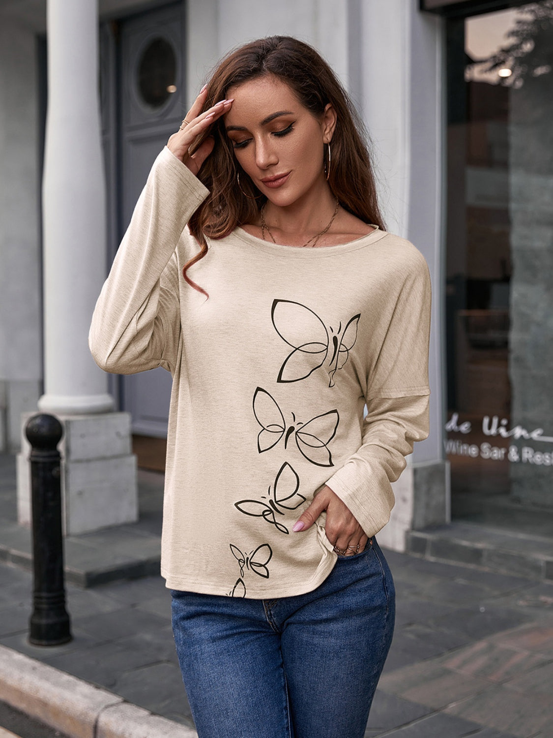 Ivory slouchy tee with butterfly graphic, long sleeves, and crew neck.