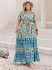 Bohemian floral maxi dress with tie waist, v-neck, short sleeves, and tiered skirt in blue and yellow.