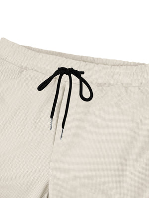 Textured waffle knit joggers in light gray with black drawstring and metal tips.