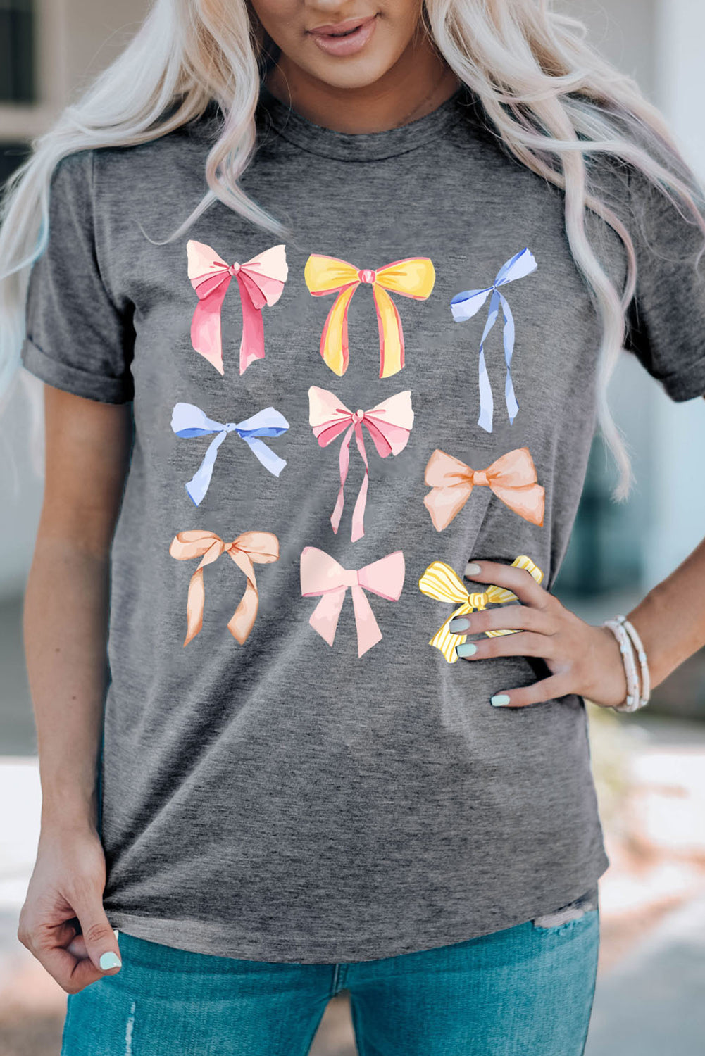 Dark gray t-shirt with a watercolor bow print featuring pink, yellow, blue, and orange bows.