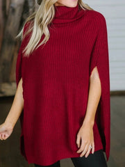 Rust cape sleeve turtleneck knit sweater with ribbed texture and side slits.