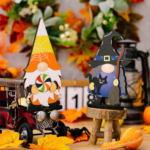 Halloween gnome figurines, one with a lollipop and spiderweb hat, another as a witch with a black cat and broom.