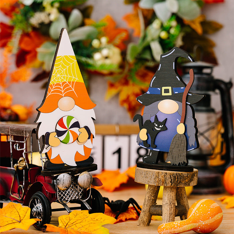 Halloween gnome figurines, one with a lollipop and spiderweb hat, another as a witch with a black cat and broom.