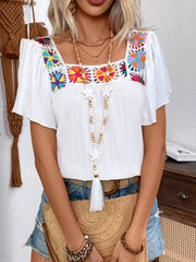 White embroidered square neck blouse with colorful floral crochet detail and flutter sleeves.