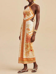Floral print backless maxi dress with halter neck and side cutouts.