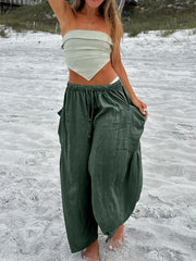 Dark green linen balloon trousers with cargo pockets and drawstring waist.