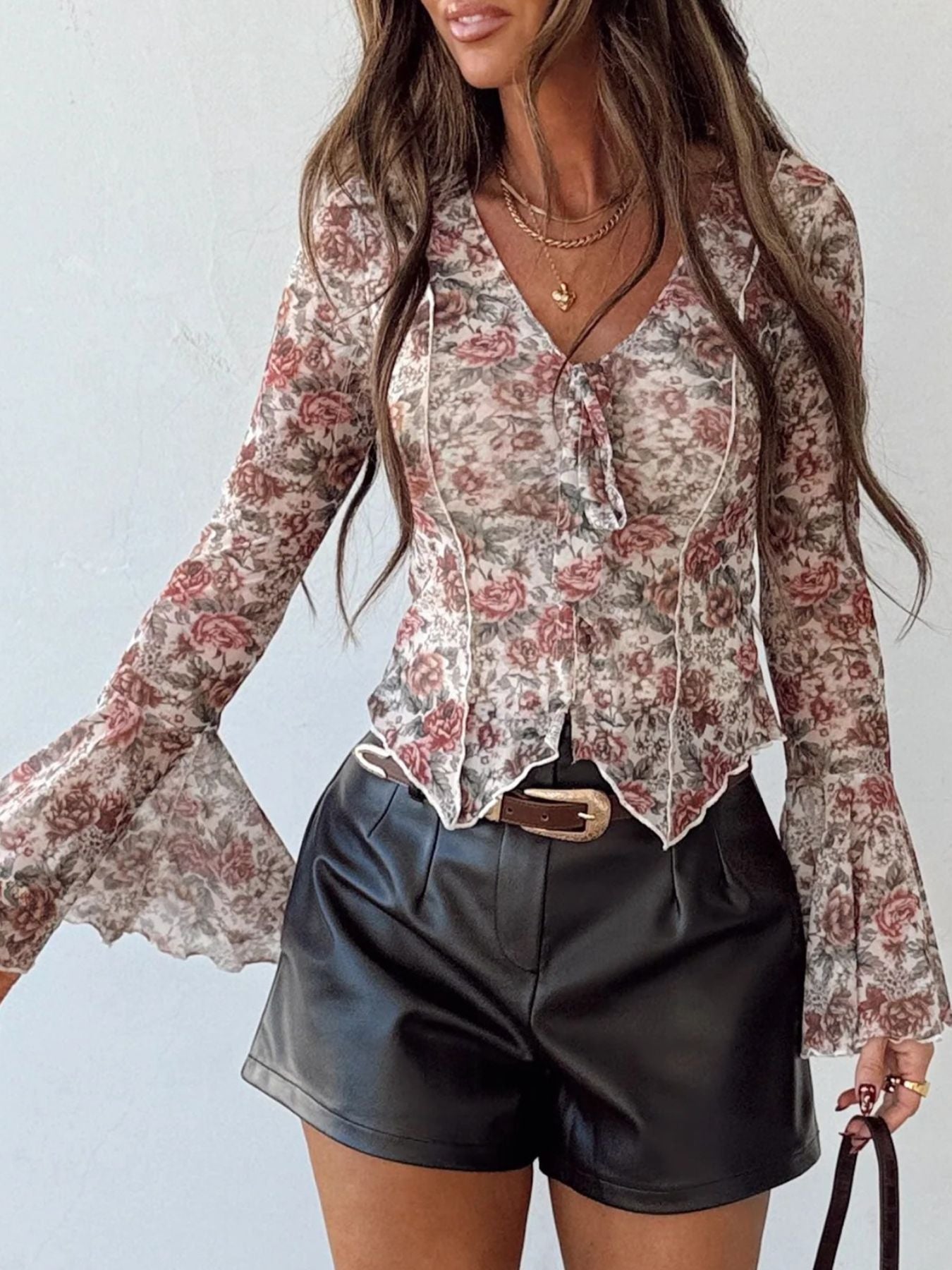 Charming floral print mesh blouse with tie-front and bell sleeves.