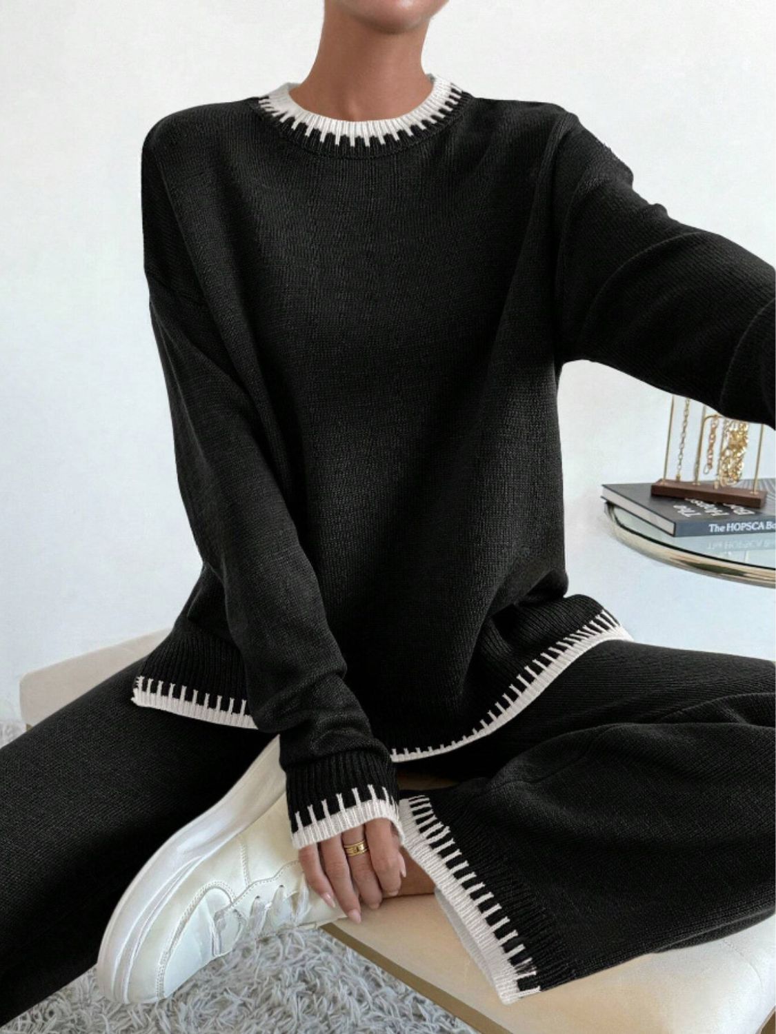Black acrylic knit loungewear set with white contrast stitching on neckline, cuffs, and hem.