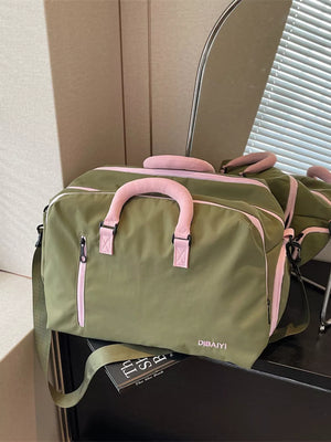 Chic olive travel bag with pink accents and adjustable strap.