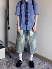 Men's relaxed fit distressed denim shorts in light wash with ripped details and wide leg.